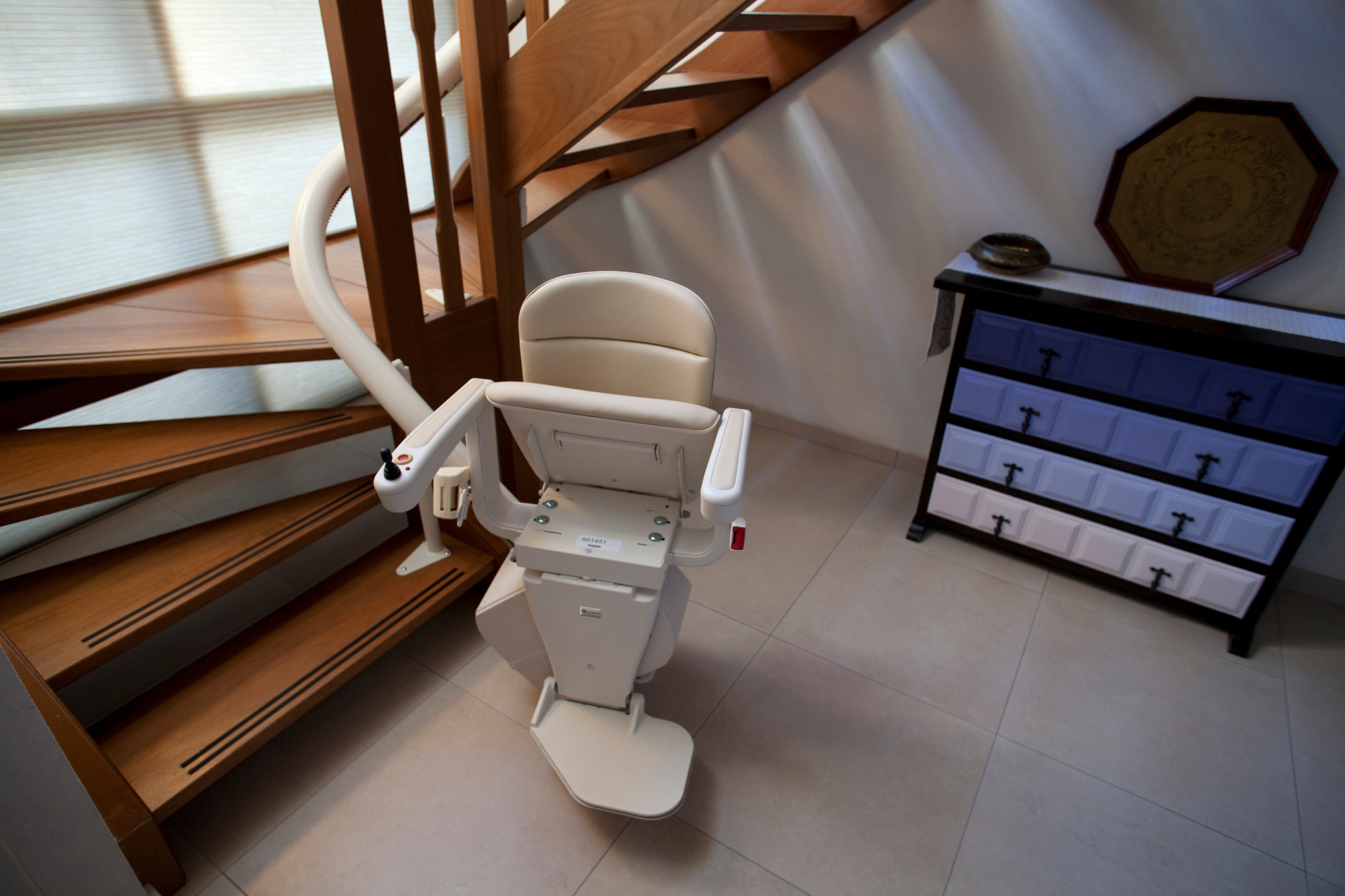 Treppenlift im bewohnten Mehrfamilienhaus — Schiene auf Bestandstreppe montiert.