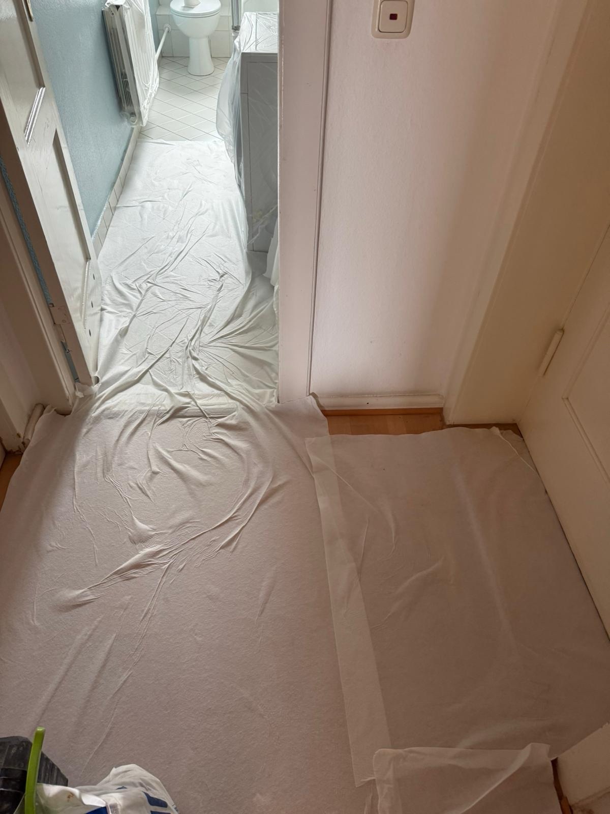 Mit selbstklebendem Vlies geschützte Laufwege in einer bewohnten Wohnung
