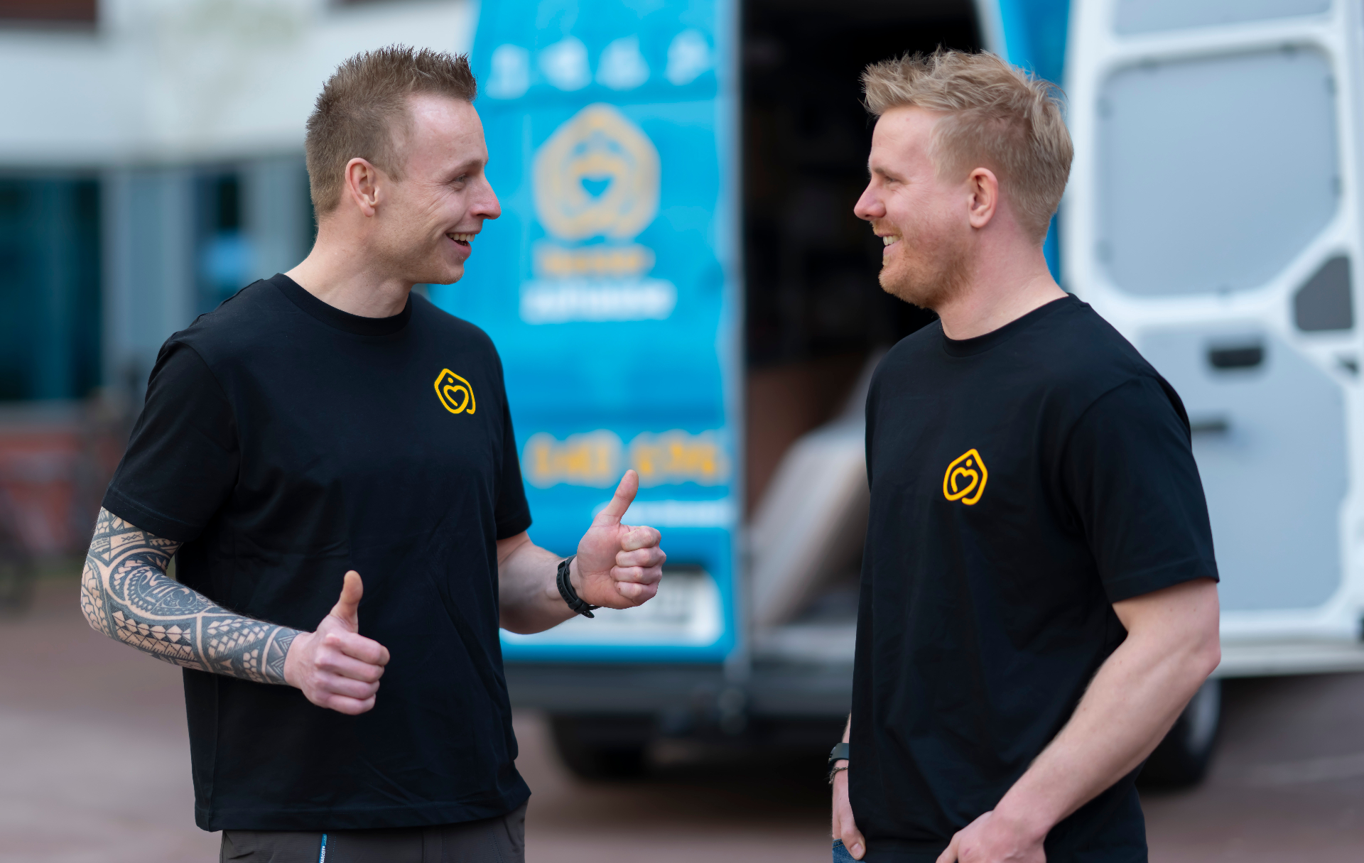 Zwei Handwerker von besser zuhause vor dem Servicefahrzeug
